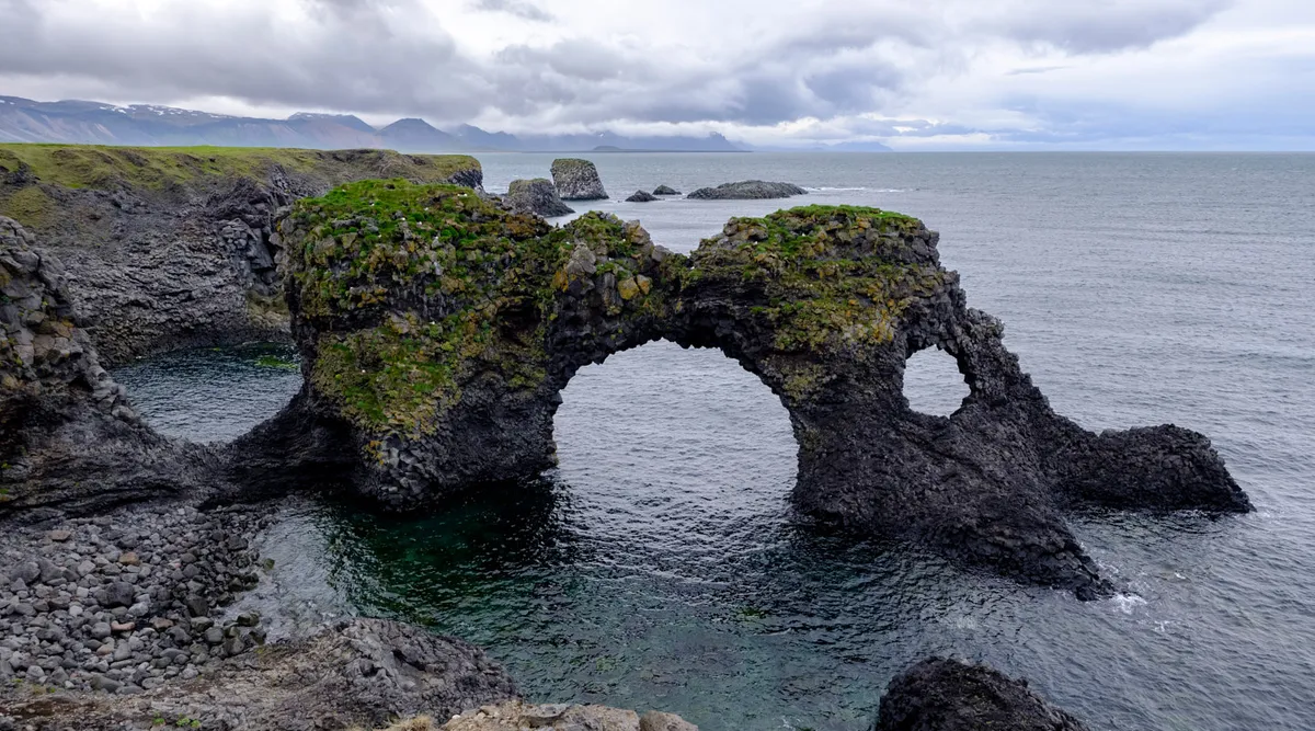 Arnarstapi coastal basalt cliffs and stone arch facing the Atlantic