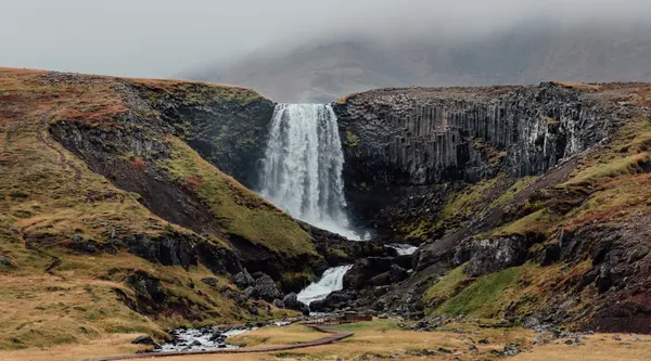 Svodufoss waterfall with Snaefellsjokull glacier in the distance